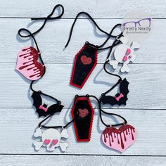 several pieces of fabric with hearts and bats on them, hanging from black cord over white wood planks