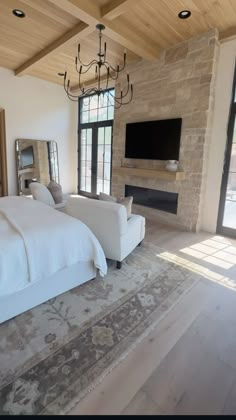 a large bed sitting in a bedroom next to a fireplace with a flat screen tv on top of it