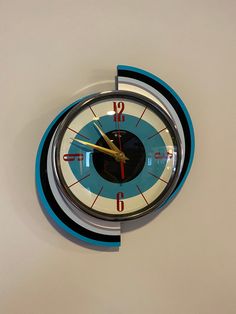 a clock that is on the side of a wall with numbers and colors in it