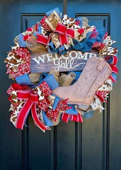 a wreath with cowboy boots and red white and blue ribbons on it that says, we own y'all