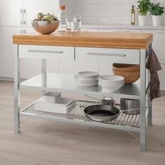 a kitchen island with pots and pans on the bottom shelf in front of it