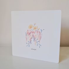 a card with two hands holding flowers on the front, and one hand in the middle