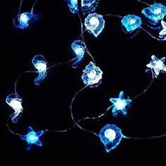 a string of blue lights on a black background with white stars and snowflakes