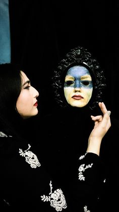 two women with their faces painted in blue and white are looking at each other's face