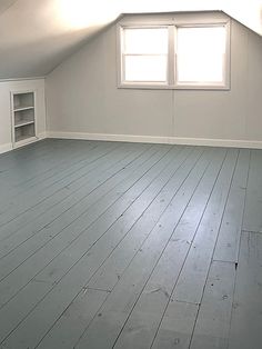 an empty room with white walls and wooden floors