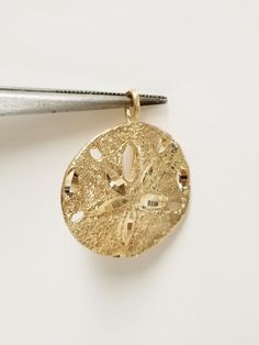 Thanks for shopping our vintage estate store. We tend to sell well below wholesale and truly hope you enjoy all of our items. Many of the items are one of a kind, so please enjoy scrolling through the pictures and hopefully something will catch your eye. Spots are from the camera or reflections. Beautiful 14k yellow gold sand dollar pendant. Length: 1" with bail Width: 3/4" Weight: 4.07 grams Bail: 1.5mm Marked is worn, testing 14k, as all our gold is marked and tested to be real gold. Beautiful pendant. As with most estate items there may be some wear on item. We do not sell new items, nor do we charge new retail prices. Engraved Gold Beach Jewelry, Vintage Gold Jewelry For The Beach, Gold Round Jewelry For The Beach, Vintage Gold Jewelry For Beach, Gold Round Jewelry For Beach, Gold Round Beach Jewelry, Vacation Gold Jewelry With Charms, Gold Round Pendant Jewelry For The Beach, Gold Charms Jewelry For Vacation