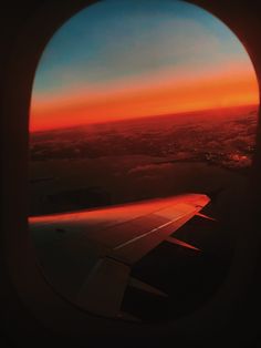 the view from an airplane window at sunset