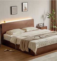 a large bed sitting next to a window in a room with wooden floors and white walls