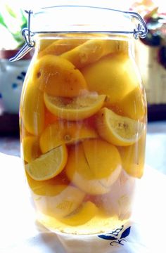 a jar filled with sliced lemons on top of a table