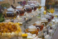 there are many different kinds of teas on the table and in glass jars with lids