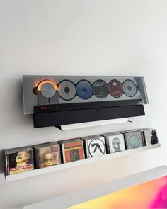 an electronic device mounted to the side of a wall with cd's on it