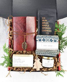 an open gift box filled with books, candles and other holiday gifts for someone who loves to read