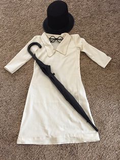 a white dress and hat on the floor with a black tie around it's neck