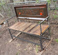 an old radio sitting on top of a wooden bench in the woods with chains hanging from it's sides