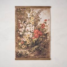 a painting hanging on the wall with flowers in it