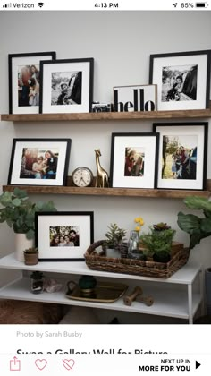 three wooden shelves filled with pictures and framed photos on top of a white shelf next to a potted plant