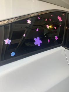 a car with pink and purple flowers on it's side view mirror, showing the sunroof