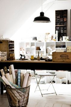 a basket full of books sitting on top of a wooden table next to a lamp