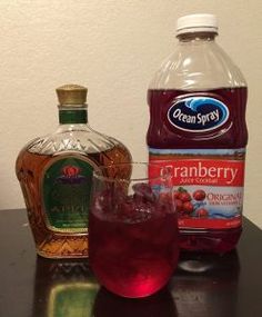 a bottle of cranberry juice next to a glass with ice