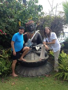 two people sitting on top of a statue