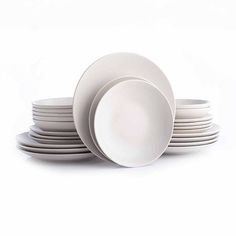 a stack of white plates sitting on top of each other in front of a white background