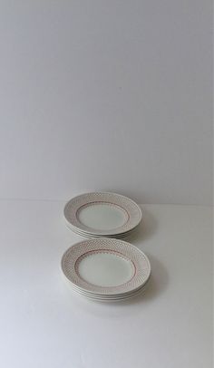 two plates sitting on top of each other in front of a white wall and floor