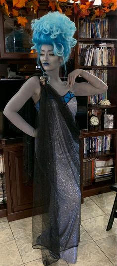 a mannequin dressed in black and silver with blue hair, wearing a dress