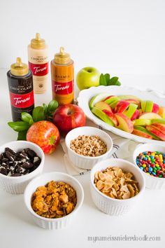 an assortment of fruits, cereals and condiments on a white table top