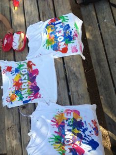 three children's t - shirts with handprints on them sitting on a picnic table