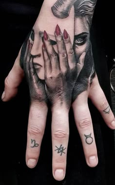 a woman's hand with tattoos on it and two hands holding each other in front of her face