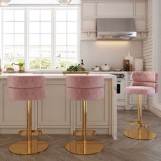 two pink velvet stools in front of a kitchen island with gold legs and brass accents