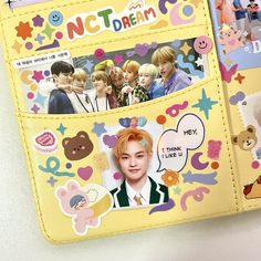 a yellow wallet with pictures and stickers on it