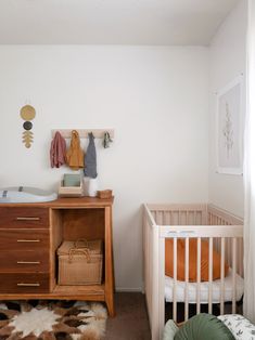 a baby's room with a crib, dresser and bed