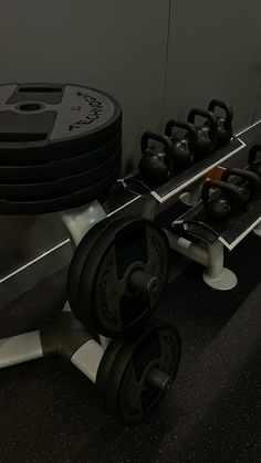 there is a row of black dumbbells on the floor next to a rack