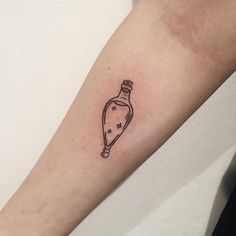 a small bottle tattoo on the arm