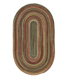 the oval rug is made from multicolored braiding and has an oval shape