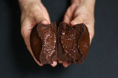 two hands holding pieces of chocolate in each other's palms, with one half eaten