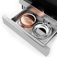 an open drawer with pots and pans in it