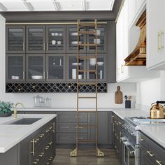 a ladder is in the middle of a kitchen with gray cabinets and gold trimmings