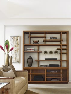 a living room filled with furniture and a large book shelf next to a couch in front of a window