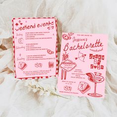 two pink menus sitting next to each other on top of a white cloth covered table