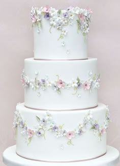 a three tiered white cake with flowers on it