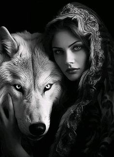 a woman holding a wolf in her arms with the wolf's head on her shoulder