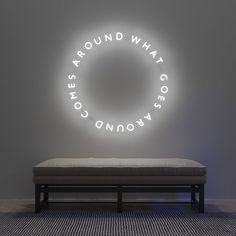 a bench sitting in front of a neon sign that says round what do you know?