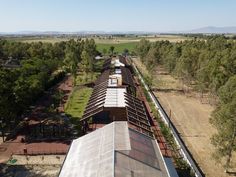 an aerial view of a train station in the middle of trees and dirt area next to it