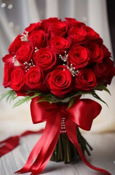 a bouquet of red roses tied with a ribbon