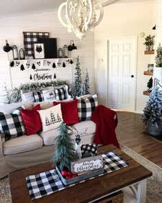 a living room decorated for christmas with black and white plaid pillows on the couches