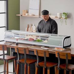 a man standing in front of a counter filled with food