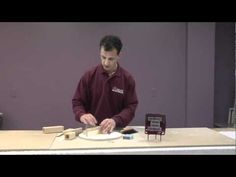 a man in a red shirt is making something on a white plate with a knife and fork