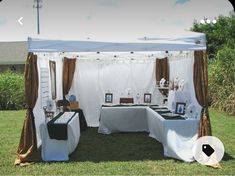 an outdoor tent set up with tables and pictures